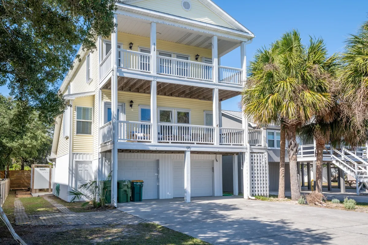 The exterior of the condo complex features palm trees, multiple balconies, and a cheerful, sunny vibe. The front steps and garage area hint at convenient access and the possibility of enjoying neighborhood strolls or relaxing outdoors.